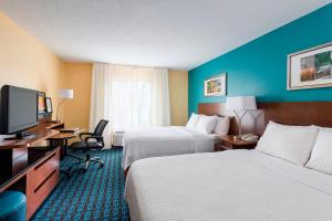 a hotel room with two beds and a flat screen tv at Fairfield Inn & Suites Naperville/Aurora in Naperville