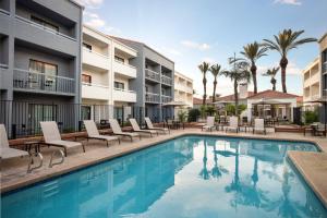 a swimming pool with lounge chairs and a hotel at Courtyard by Marriott Phoenix Mesa in Mesa