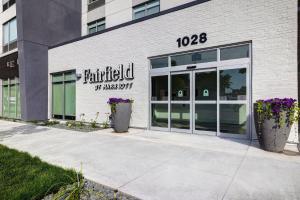 Fairfield by Marriott Inn & Suites Minneapolis Downtown في مينيابوليس: مبنى من الطوب الأبيض مع علامة وطنية عليه