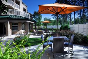 a patio with a table and an umbrella at Courtyard Wausau in Wausau