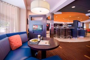 a living room with a blue couch and a table at Courtyard Wausau in Wausau