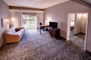 a hotel room with a couch and a desk and a television at Courtyard Wausau in Wausau