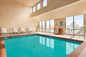 a swimming pool in a hotel with chairs and windows at Boulder Marriott in Boulder