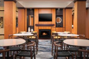 a restaurant with tables and chairs and a fireplace at Fairfield Inn & Suites Chattanooga I-24/Lookout Mountain in Chattanooga