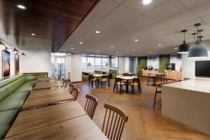 a restaurant with wooden tables and chairs and a bar at Fairfield Inn & Suites by Marriott Oakhurst Yosemite in Oakhurst