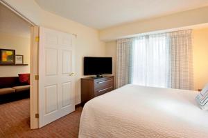 a bedroom with a bed and a flat screen tv at Residence Inn Fort Wayne Southwest in Fort Wayne