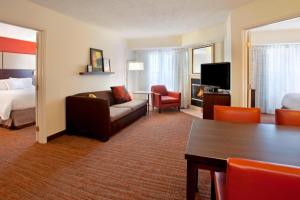 a hotel room with a couch and a bed at Residence Inn Fort Wayne Southwest in Fort Wayne