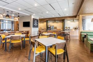 a dining room with tables and yellow chairs at Fairfield Inn & Suites by Marriott Dallas DFW Airport North Coppell Grapevine in Coppell