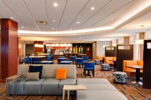a lobby with a couch and tables and chairs at Courtyard by Marriott Chicago Schaumburg/Woodfield Mall in Schaumburg