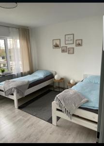 a bedroom with two beds and a window at FeWo mit Terasse Neuwied & Koblenz in Neuwied