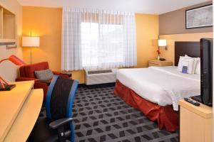 a hotel room with a large bed and a television at TownePlace Suites by Marriott Las Vegas Henderson in Las Vegas