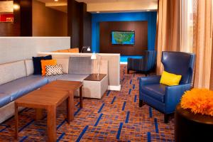 a lobby with a couch and two chairs and a table at Courtyard by Marriott Rockford in Rockford