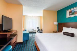 a hotel room with a bed and a flat screen tv at Fairfield Inn & Suites Jackson in Jackson