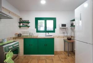 a kitchen with green cabinets and a white refrigerator at Cottage Eco-Friendly Barcelona country side in La Garriga