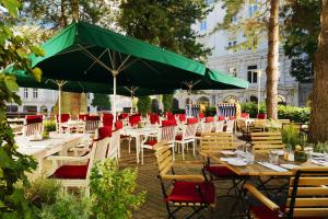 a group of tables and chairs with a green umbrella at Hamburg Marriott Hotel in Hamburg