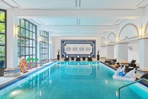 a large swimming pool in a room with a living room at Hamburg Marriott Hotel in Hamburg