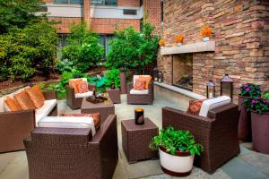 a patio with wicker chairs and a fireplace at Trumbull Marriott Shelton in Trumbull