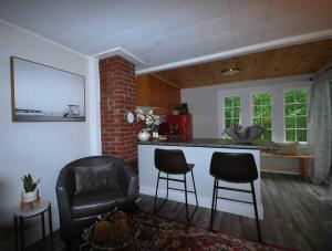 a living room with a kitchen with a counter and chairs at Spacious 1 Bedroom Cottage Close to Everything 3 in Edgecomb