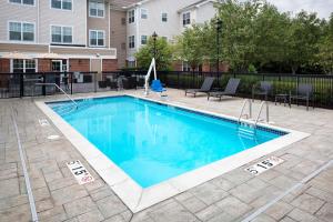 a swimming pool at a apartment complex with a building at Residence Inn Milford in Milford