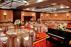 une salle de banquet avec des tables blanches et un piano dans l'établissement Trumbull Marriott Shelton, à Trumbull