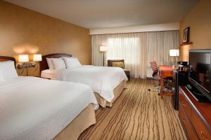 a hotel room with two beds and a flat screen tv at Courtyard Seattle North / Lynnwood Everett in Lynnwood