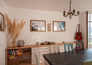 eine Küche mit einem Tisch und einer Gitarre an der Wand in der Unterkunft Villa de Melle – Seaview – beach 5 min by foot in Ferrol