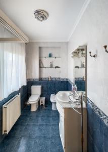a blue bathroom with a toilet and a sink at Villa de Melle – Seaview – beach 5 min by foot in Ferrol