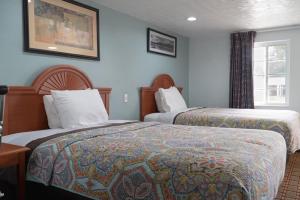 a hotel room with two beds and a window at Bestway Inn in Muncie