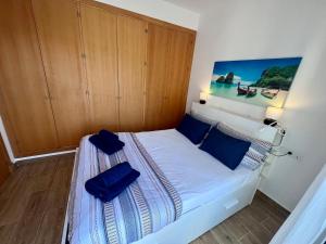 niewielka sypialnia z łóżkiem z niebieskimi poduszkami w obiekcie GATU Villa Atardecer en la playa de las Redes " Preferente mayores de 21 años y familias " w mieście El Puerto de Santa María