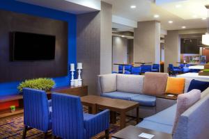 a lobby with blue chairs and a waiting room at Courtyard by Marriott Bloomington in Bloomington