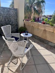 dwa krzesła i stół na patio w obiekcie GATU Villa Atardecer en la playa de las Redes " Preferente mayores de 21 años y familias " w mieście El Puerto de Santa María