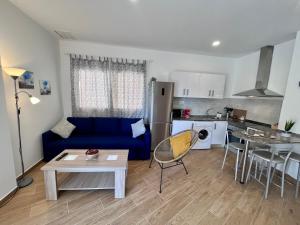 salon z niebieską kanapą i kuchnią w obiekcie GATU Villa Atardecer en la playa de las Redes " Preferente mayores de 21 años y familias " w mieście El Puerto de Santa María