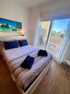 sypialnia z dużym łóżkiem z niebieskimi poduszkami w obiekcie GATU Villa Atardecer en la playa de las Redes " Preferente mayores de 21 años y familias " w mieście El Puerto de Santa María