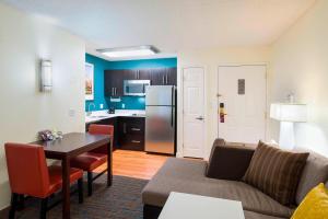 a living room with a couch and a table and a kitchen at Residence Inn Boston Framingham in Framingham