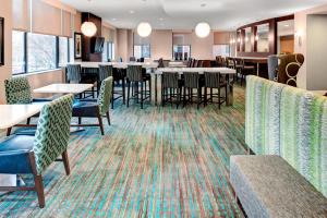 Residence Inn Atlanta Midtown 17th Street في أتلانتا: غرفة طعام مع طاولات وكراسي وبار