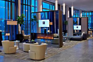 eine Lobby mit Sofas und Stühlen sowie einem Kamin in der Unterkunft AC Hotel Columbus Dublin in Dublin