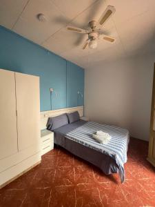 - une chambre avec un lit et un ventilateur de plafond dans l'établissement P&R hostals Can Tort, à Tossa de Mar