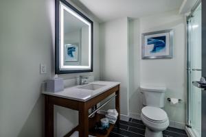 a bathroom with a sink and a toilet and a mirror at Four Points by Sheraton Brunswick in Brunswick +12 photos