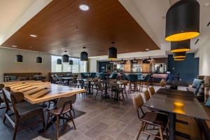 a restaurant with tables and chairs and a bar at Four Points by Sheraton Brunswick in Brunswick