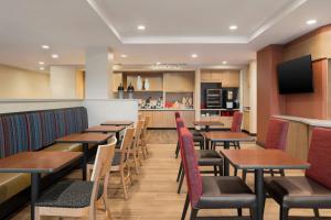 a restaurant with wooden tables and chairs and a kitchen at TownePlace Suites by Marriott Dubuque Downtown in Dubuque