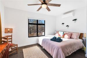 a bedroom with a bed and a ceiling fan at Cozy Fresh Desert Hideaway, 5 mins to Joshua Tree in Twentynine Palms