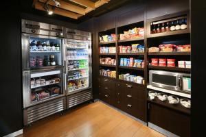 a kitchen with a refrigerator and lots of food at Courtyard Dallas Las Colinas in Irving