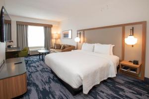 a hotel room with a large bed and a television at Fairfield by Marriott Inn & Suites Newport Cincinnati in Newport