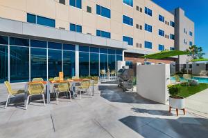 un patio avec des tables et des chaises en face d'un bâtiment dans l'établissement Element Waco, à Waco