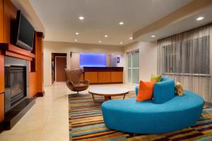 a living room with a blue couch and a table at Fairfield Inn & Suites Fort Worth University Drive in Fort Worth