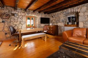 a living room with a wooden desk and a stone wall at Holiday Home Oliti with Pool in Mošćenice