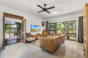 a living room with a couch and a ceiling fan at Casa De Playa - Beach Townhouse in Holloways Beach