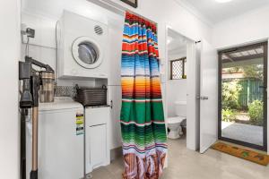 a kitchen with a colorful curtain in a kitchen at Casa De Playa - Beach Townhouse in Holloways Beach +8 photos