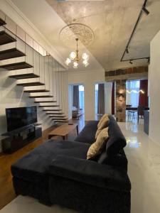 - un salon avec un canapé noir et un escalier dans l'établissement Dark Apartment, à Erevan