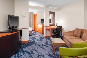een woonkamer met een bank en een televisie in een hotelkamer bij Fairfield Inn & Suites Indianapolis Avon in Avon